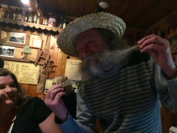 Snekutis, a grey-haired man, shows off his long moustache.