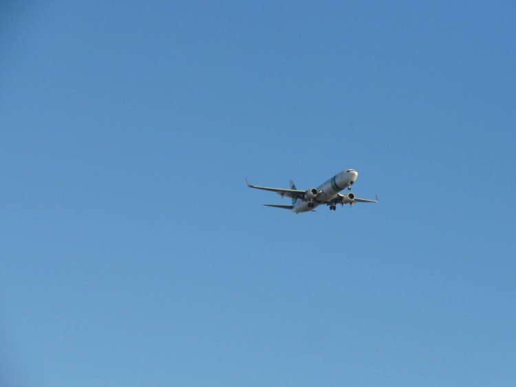 Plane flying in blue sky. 