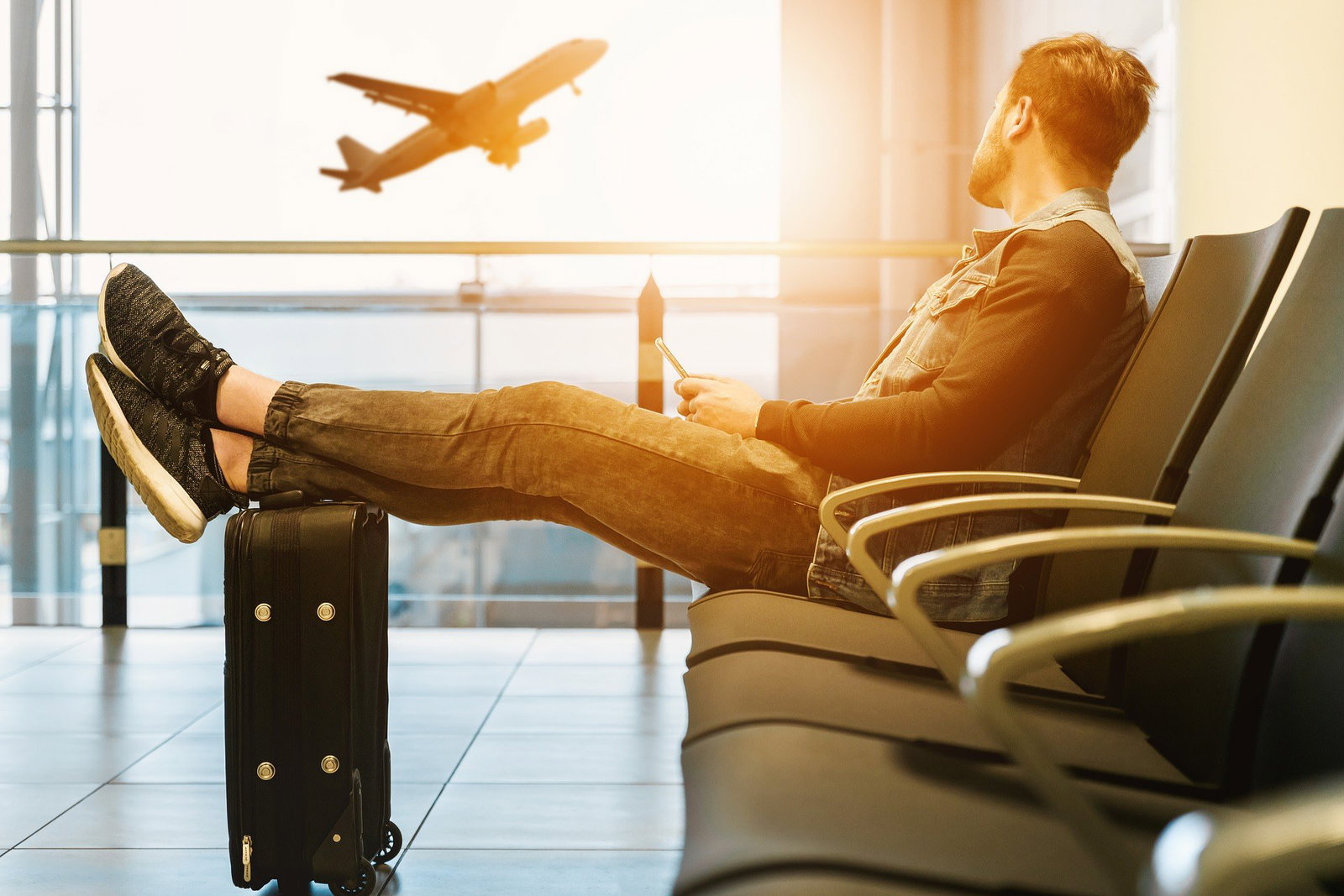 What to do when things go wrong with your flight 3 Man watching plane take off in airport.