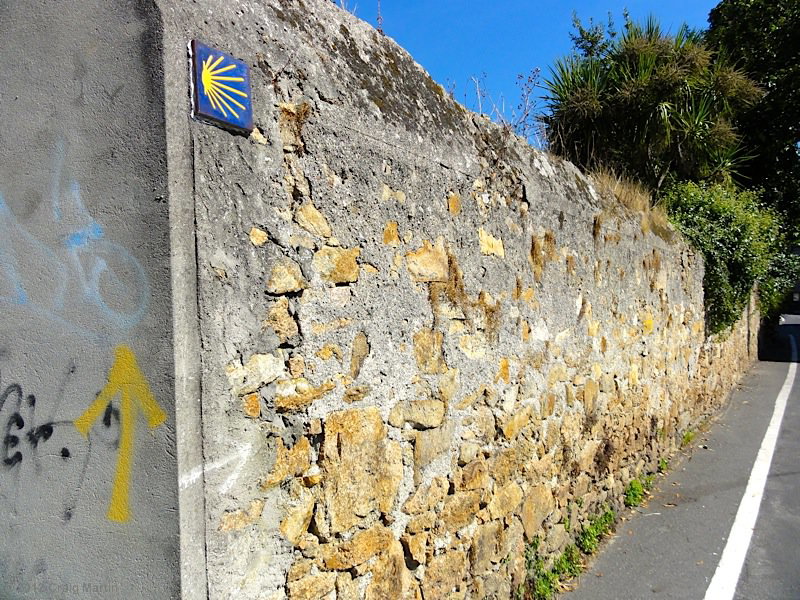 Two waymarks: the arrow and the scallop shell.